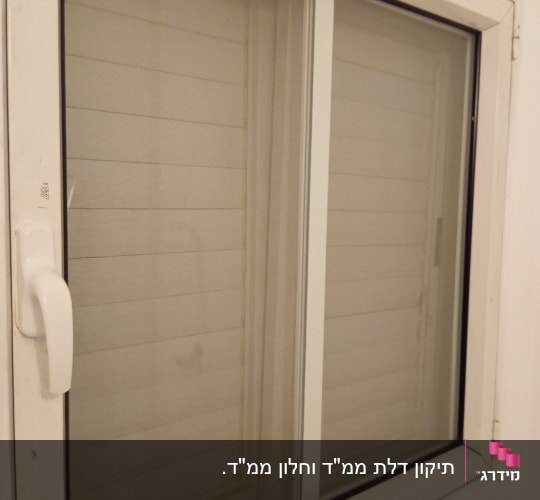 חלון עם ידית לבנה ומסגרת מתכת